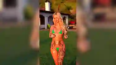 С волнистыми волосами татуированная баба с классной жопой стоит на солнышке